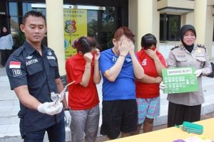 Ketiga tersangka didampingi petugas.