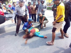 Korban tersungkur di tengah jalan.