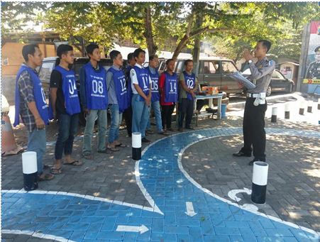 Bripka Arifin, saat memberikan petunjuk pada pemohon SIM dalam ujian praktek