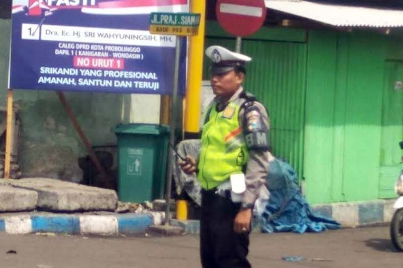 Bripka Andhy Apriansyah, anggota Satlantas Polres Probolinggo kota saat melaksanakan tugas pengaturan lalu lintas poros pagi.