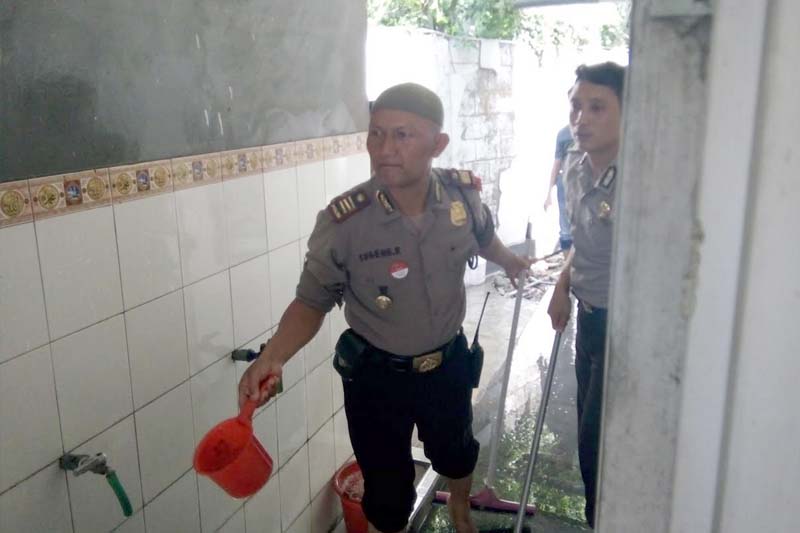 AKP Sugeng dan Bripka Yudi membersihkan tempat wudhu masjid Al Ikhlas.