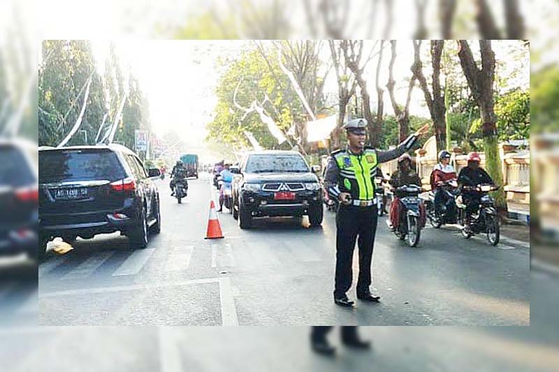 Brigpol Putu Dewanta SH, anggota satlantas Polresta Probolinggo saat melakukan pengaturan Lalin di Jalan Soekarno-Hatta.