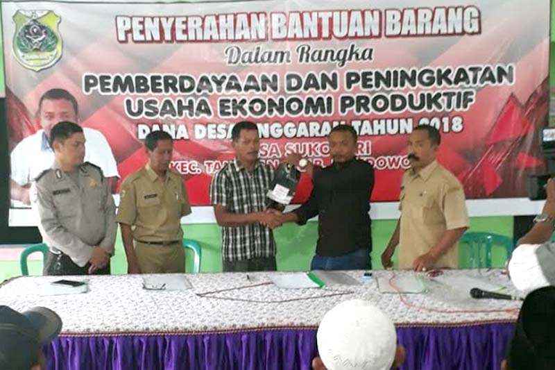 Kepala desa sukosari saat menyerahkan bantuan barang kepada masyarakat